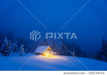 A winter landscape featuring an isolated wooden cabin A winter landscape featuring an isolated wooden cabin 108536428
