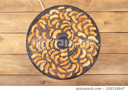 Top view of an open dryer for vegetables and fruits with dried apples. Top view of an open dryer for vegetables and fruits with dried apples. 108538647