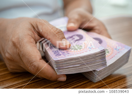 Asian business woman holding Thai banknote currency money. 108539043
