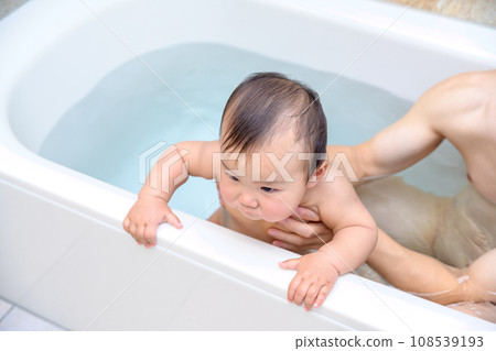 Baby being bathed by his father, happy smiling infant, Ikumen, childcare leave, 0 year old infant, bathtub bathroom Baby being bathed by his father, happy smiling infant, Ikumen, childcare leave, 0 year old infant, bathtub bathroom 108539193