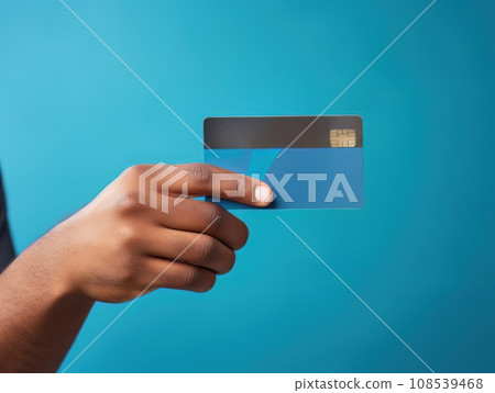 Male hand holding a blue bank card on a blue background AI 108539468