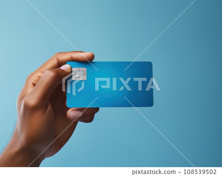 Male hand holding a blue bank card on a blue background AI 108539502