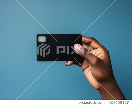Male hand holding a black bank card on a blue background AI 108539507
