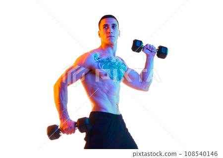 Shirtless young man with strong, muscular fit body training with dumbbells against white studio background in neon light 108540146