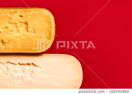 Textures of different cheese, Parmesan, pecorino, cheddar against red background. Cheese production and store Textures of different cheese, Parmesan, pecorino, cheddar against red background. Cheese production and store 108540968