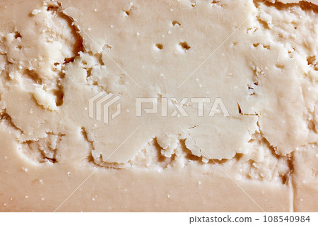 Texture of delicious, organic, natural hard cheese. Sliced. Wallpaper, background. 108540984