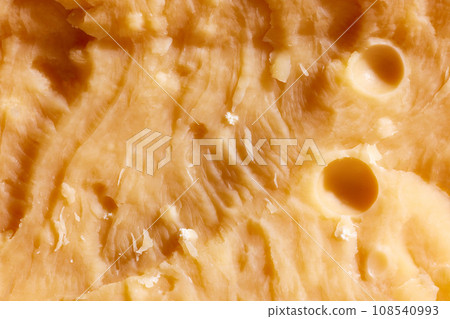 Close-up image, texture of yellow colored, hard cheese, Parmesan. Traditional taste of Italian cheese. Salty and delicious 108540993
