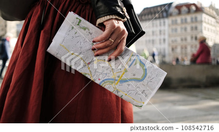 Female Tourist Strolls Through Central Streets In Dresden, Carrying City Map With Sightseeings 108542716