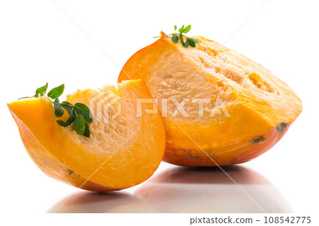 A piece of ripe orange pumpkin with seeds on a white background. 108542775