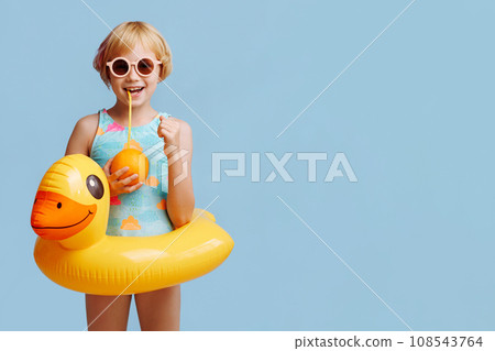 Child with inflatable duck ring on blue background with copy space. Child with inflatable duck ring on blue background with copy space. 108543764