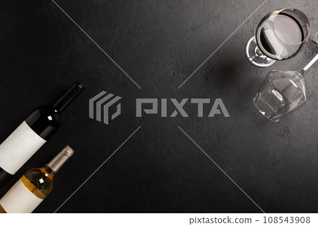 Glasses and bottles with red and white wine on black. Flat lay Glasses and bottles with red and white wine on black. Flat lay 108543908