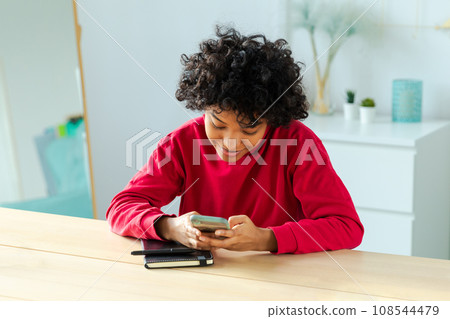 African girl holding smartphone touch screen typing scroll page at home. Woman with cell phone surfing internet using social media apps playing game. Shopping online Internet news cellphone addiction African girl holding smartphone touch screen typing scroll page at home. Woman with cell phone surfing internet using social media apps playing game. Shopping online Internet news cellphone addiction 108544479
