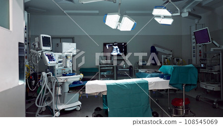 Empty, dark hospital and room for operation, emergency service and healing patient. Healthcare backgrounds, surgery theatre and interior of bed, machine and medical tools for wellness, help and risk 108545069