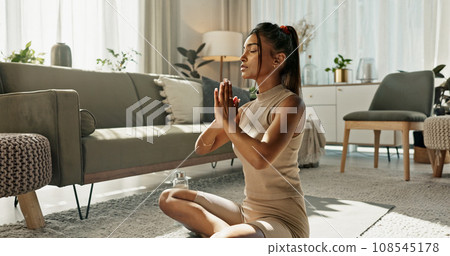 Woman, wellness and fitness with lotus pose on living room floor for zen, mental health and focus at home. Indian, person or meditation in peace with yoga, chakra training and spiritual awareness 108545178