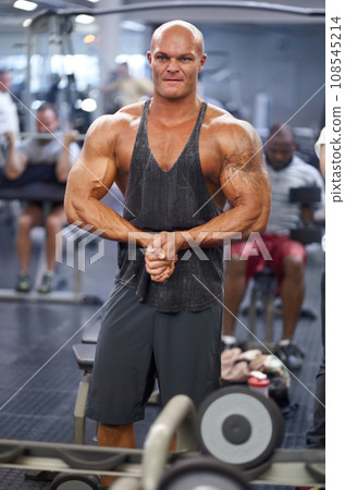 Man, arm flex and mirror at gym with fitness, workout and exercise of bodybuilder with reflection. Muscle, male person and athlete with sport training, wellness and body builder at a health club 108545214