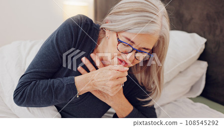 Sick, cough and senior woman in bed with allergies, flu or cold on a weekend morning at home. Illness, chest pain and elderly female person in retirement with asthma or infection in bedroom at house. 108545292