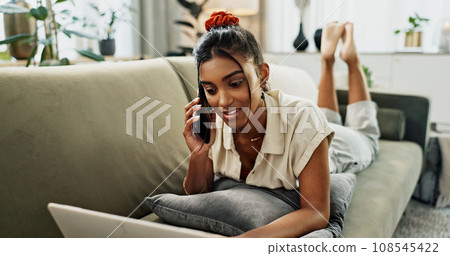 Remote work, phone call woman on a sofa with laptop, conversation or break at home. Smartphone, app and female with contact, communication and checking email, review or feedback in a living room 108545422