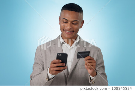 Business man, credit card and phone in studio for ecommerce, financial accounting or banking investment on blue background. Happy worker, mobile and fintech for online shopping, stock trading or deal Business man, credit card and phone in studio for ecommerce, financial accounting or banking investment on blue background. Happy worker, mobile and fintech for online shopping, stock trading or deal 108545554