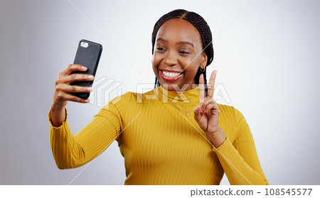 Studio, peace sign or black woman taking selfie on social media with confidence, post or smile. African lady, memory or happy influencer taking a photograph, vlog or picture online on grey background 108545577