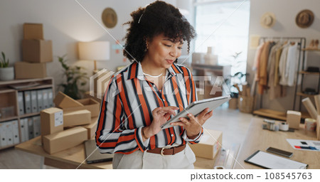 Tablet, small business and woman with supply chain logistics and order information for shipping. Home, entrepreneur and ecommerce of a female person with boxes for distribution and delivery of stock Tablet, small business and woman with supply chain logistics and order information for shipping. Home, entrepreneur and ecommerce of a female person with boxes for distribution and delivery of stock 108545763