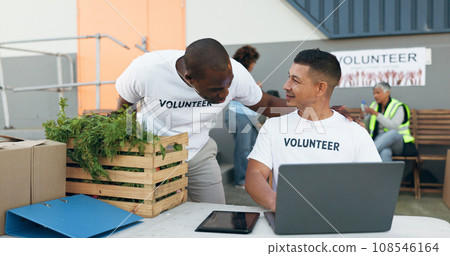 Team, volunteer and laptop for donation, charity and outreach program by people outdoor. Tech, collaboration and men in nonprofit, support and social responsibility, community service and NGO 108546164