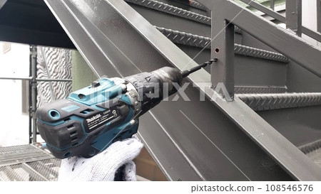 Drilling work to create an escape route for rainwater at the base of the handrail 108546576