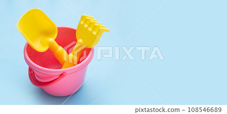 Plastic toys, shovels in bucket on blue background. Summer background concept Plastic toys, shovels in bucket on blue background. Summer background concept 108546689
