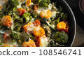 Gratin with broccoli, carrots and cheese baked in the oven on a dark wooden table, close up 108546741