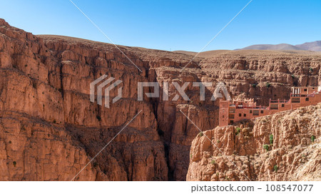 Hotel at the top of Dades Gorges, a series of canyons formed by the Dades River. Red and orange rock formations create a dramatic and picturesque landscape. 108547077