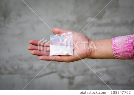 Bag of white powder in his hands. Image for prohibited substances, addiction concep 108547762