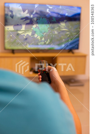 Hand holding TV remote control Hand holding TV remote control 108548363