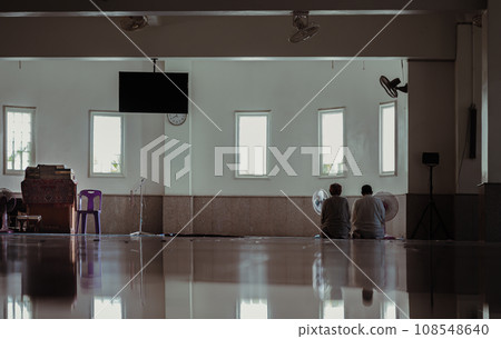 Religious two muslim men are sit praying inside the mosque. 108548640