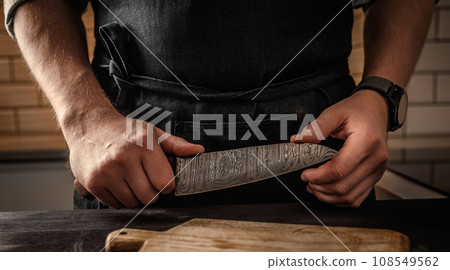 Chief with a big knife and cutting board in the kitchen Chief with a big knife and cutting board in the kitchen 108549562