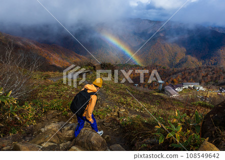 一個孩子在秋葉和彩虹的谷川山上行走。 108549642
