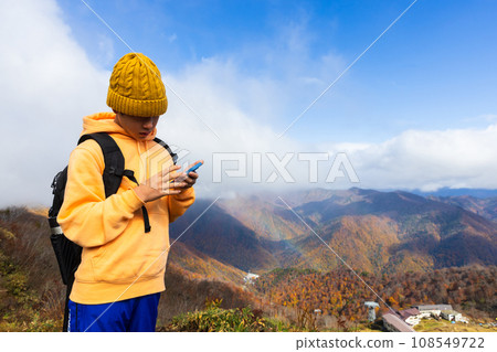 A child taking pictures of scenery with a smartphone 108549722