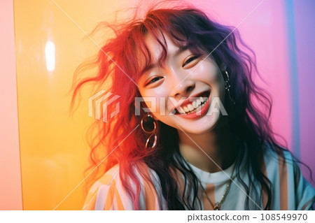 a woman with bright hair smiling in front of a colorful wall 108549970