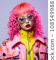 a woman with bright pink hair wearing sunglasses and a colorful jacket 108549988