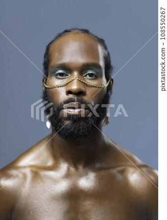 Black serious gay stands isolated on blue background Black serious gay stands isolated on blue background 108550267