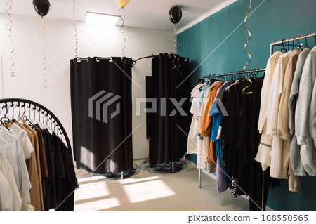 Clothes on hangers hang on the rack in a clothing store Clothes on hangers hang on the rack in a clothing store 108550565