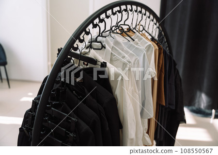 Clothes on hangers hang on the rack in a clothing store Clothes on hangers hang on the rack in a clothing store 108550567