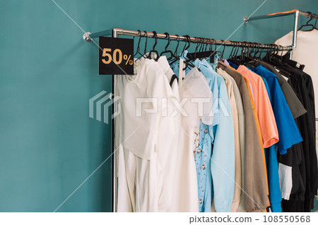 Discounted clothes on hangers hang on the rack in a clothing store 108550568
