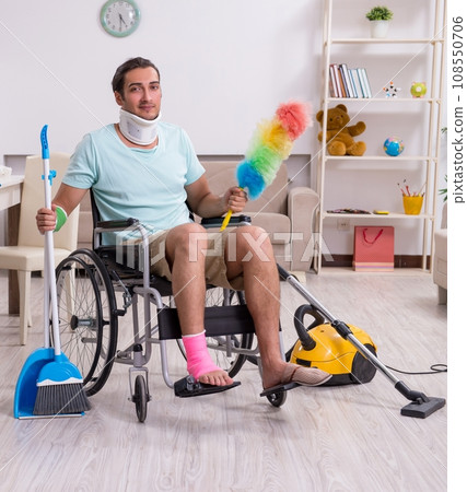 Young man in wheel-chair cleaning the house 108550706