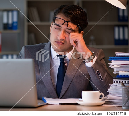 Businessman staying in the office for long hours 108550726
