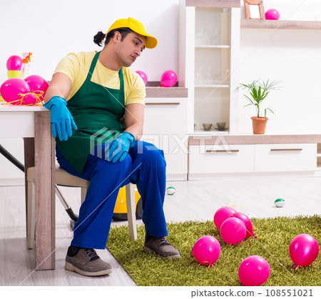 Young male contractor doing housework after party Young male contractor doing housework after party 108551021