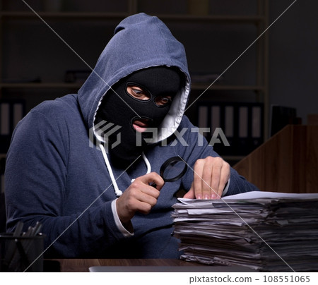 Male thief in balaclava in the office night time 108551065