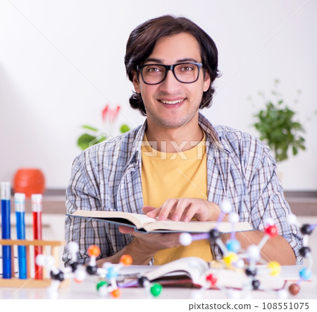 Young student physicist preparing for exam at home Young student physicist preparing for exam at home 108551075