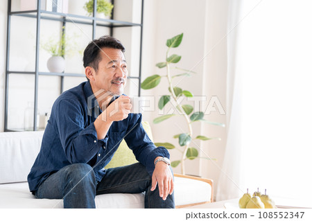 A senior man relaxing in the living room. 108552347