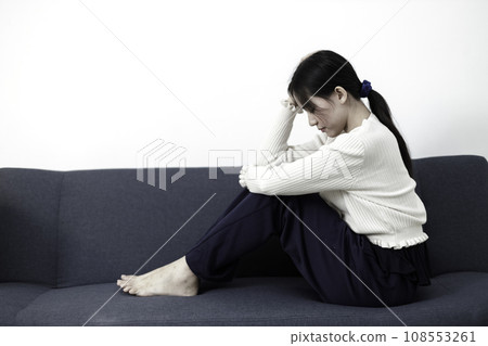Female having depression sitting alone on sofa. woman headache unhappy emotion. Female having depression sitting alone on sofa. woman headache unhappy emotion. 108553261