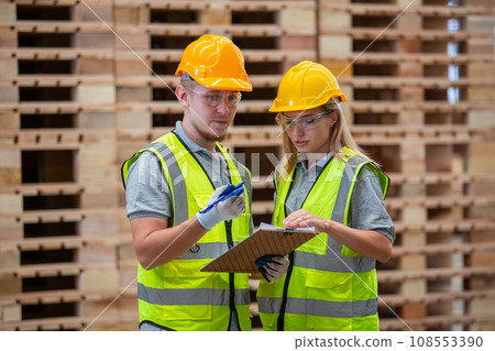 Team engineer carpenter wearing safety uniform and hard hat working holding clipboard Team engineer carpenter wearing safety uniform and hard hat working holding clipboard 108553390