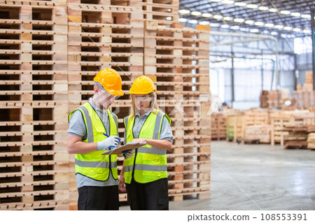Team engineer carpenter wearing safety uniform and hard hat working holding clipboard checking 108553391